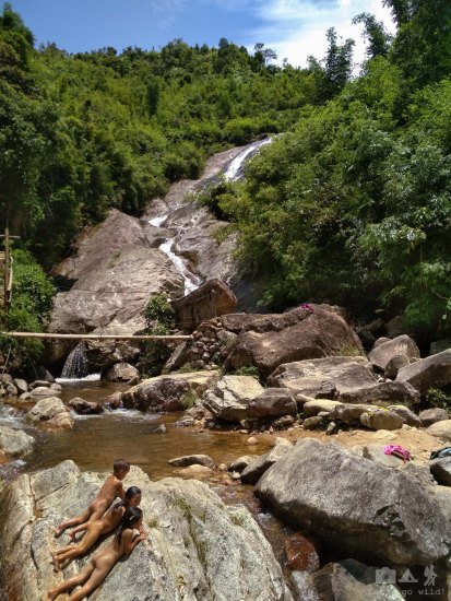 Local kids having a refreshing bath right next to a tourist path